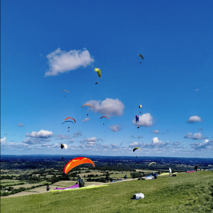 a group of people flying kites in a field