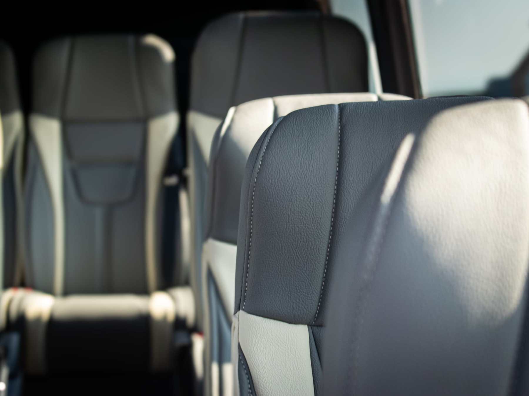 Close-up of gray car seats with stitching detail inside a vehicle.